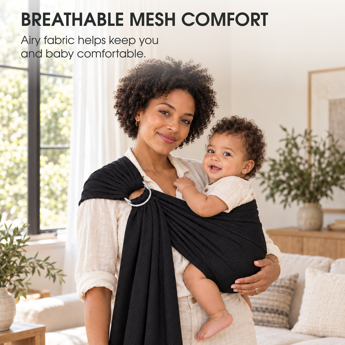 A mother carrying her baby in a black mesh ring sling, with text about breathable comfort